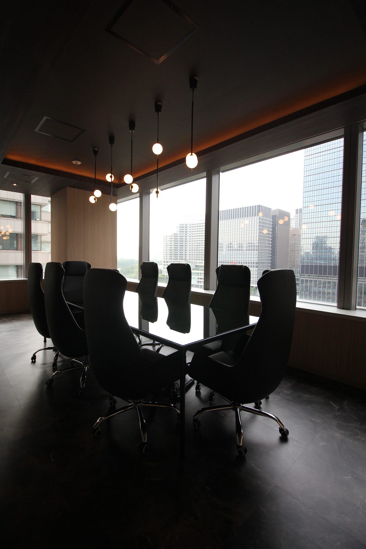街を見下ろす、ダークトーンの会議室（丸の内オフィス）